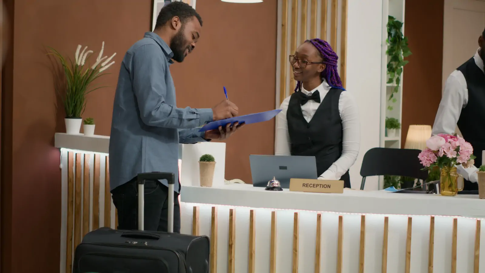 Hospitality and tourism professionals welcoming a hotel guest